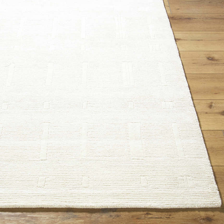 Close up of the Charan Ivory Cream Area Rug showing its textured, geometric pattern and 100% wool material. Front