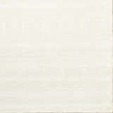Close-up of a hand-tufted Charan Ivory Cream area rug with a raised, geometric pattern and textured wool. Corner