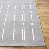 Close up of the Charan Slate Gray Area Rug. Hand tufted wool rug with ivory stripes and dots. Contemporary style. Front