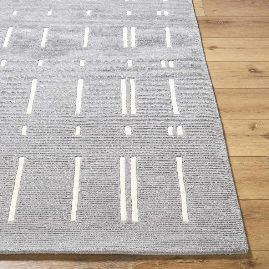 Close up of the Charan Slate Gray Area Rug. Hand tufted wool rug with ivory stripes and dots. Contemporary style. Front