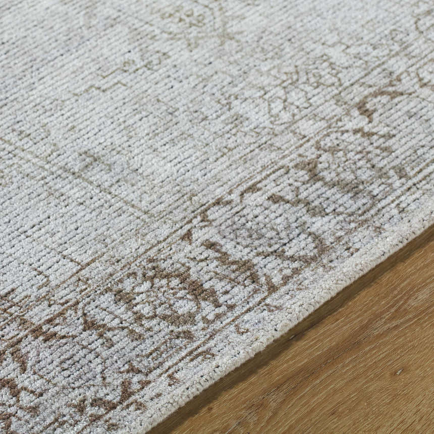 Close-up of the Clodia Area Rug showing its charcoal, ivory, and taupe traditional pattern and hand-tufted texture. Texture