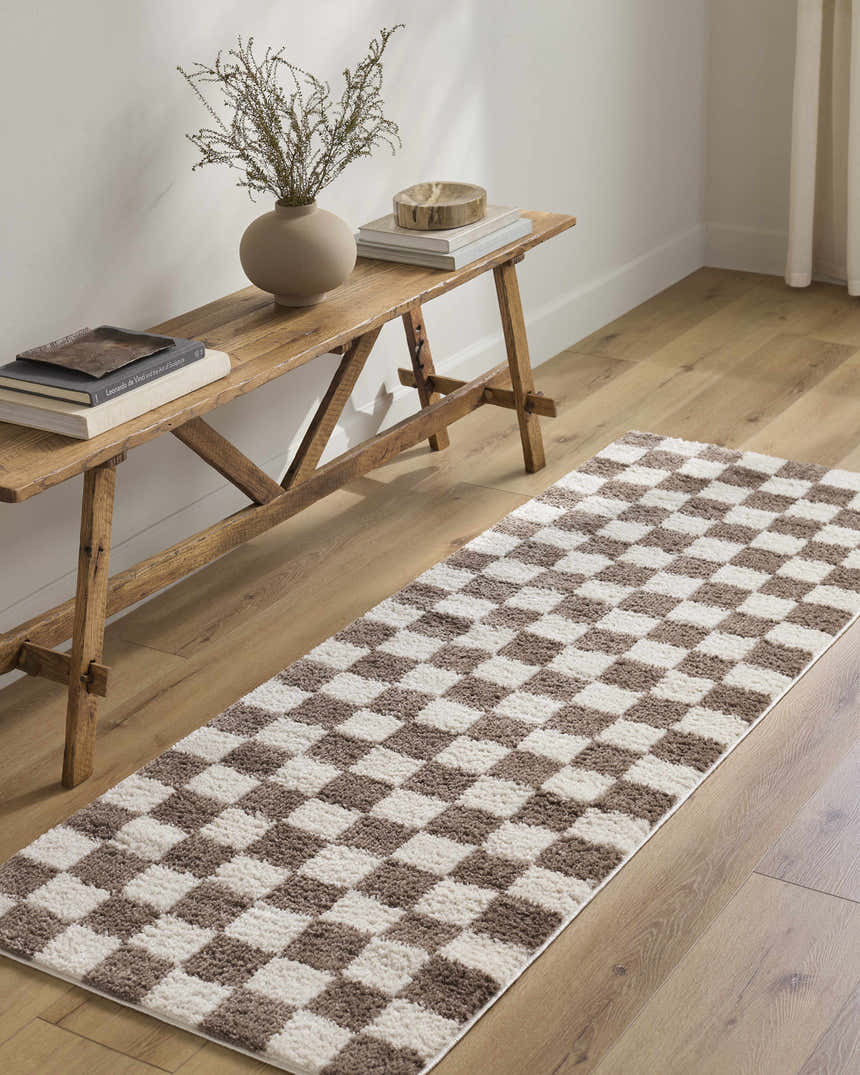 Hallway scene with a Canika Brown Washable Checkered Area Rug, wood bench, vase, books, and light wood floors. Roomscene-Runner