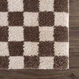 Close up of the Canika Brown Washable Checkered Area Rug showing its dark brown and beige checkerboard pattern. Swatch