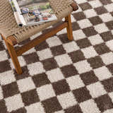 Close-up of the Canika Brown Washable Checkered Area Rug, showing its dark brown and peach checkerboard pattern and soft texture. Styleshot