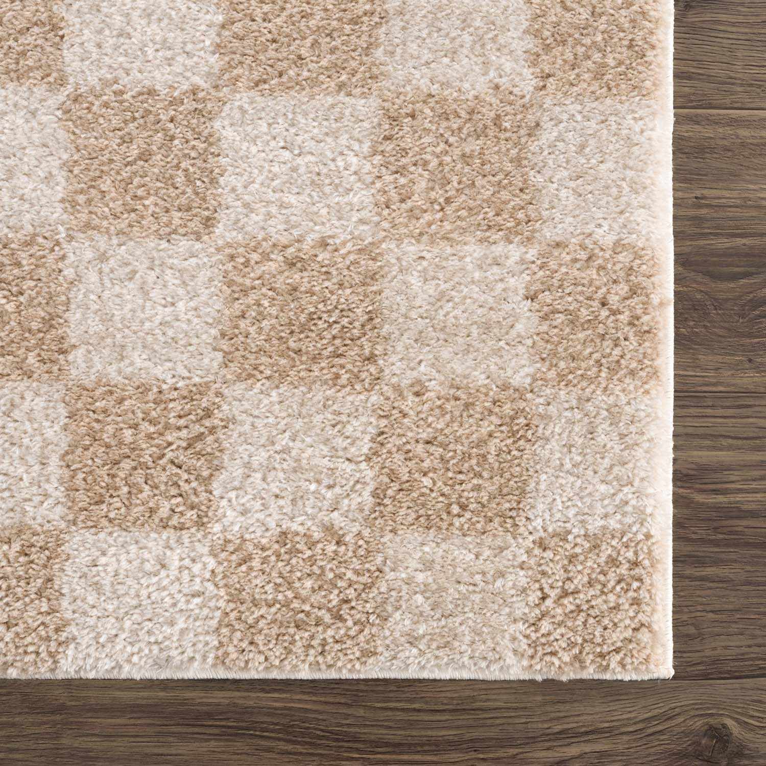Close-up of Canika Checkered Cream Washable Area Rug. Beige and peach checkerboard pattern, soft polyester texture. Swatch
