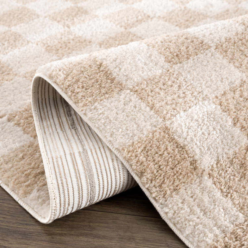 Close-up of the Canika Checkered Cream Washable Area Rug showing its beige checkerboard pattern and soft, plush texture. Fold