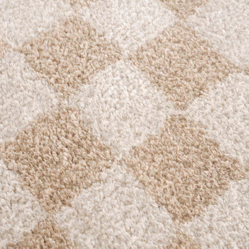 Close-up of Canika Checkered Cream Washable Area Rug. Beige and peach checkered pattern, soft polyester texture. Texture