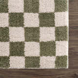 Close-up of the Canika Green Checkered Washable Plush Rug, featuring a soft, textured green and off-white checkerboard pattern. Swatch