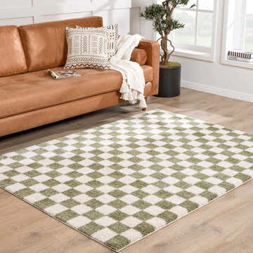 Living room with tan leather sofa and Canika Green Checkered Washable Plush Rug on wood floor. Roomscene-Rectangle