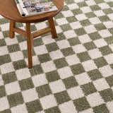 Close-up of Canika Green Checkered Washable Plush Rug. Green and off-white checkerboard pattern with a soft, plush texture. Styleshot