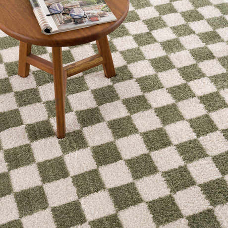 Close-up of Canika Green Checkered Washable Plush Rug. Green and off-white checkerboard pattern with a soft, plush texture. Styleshot