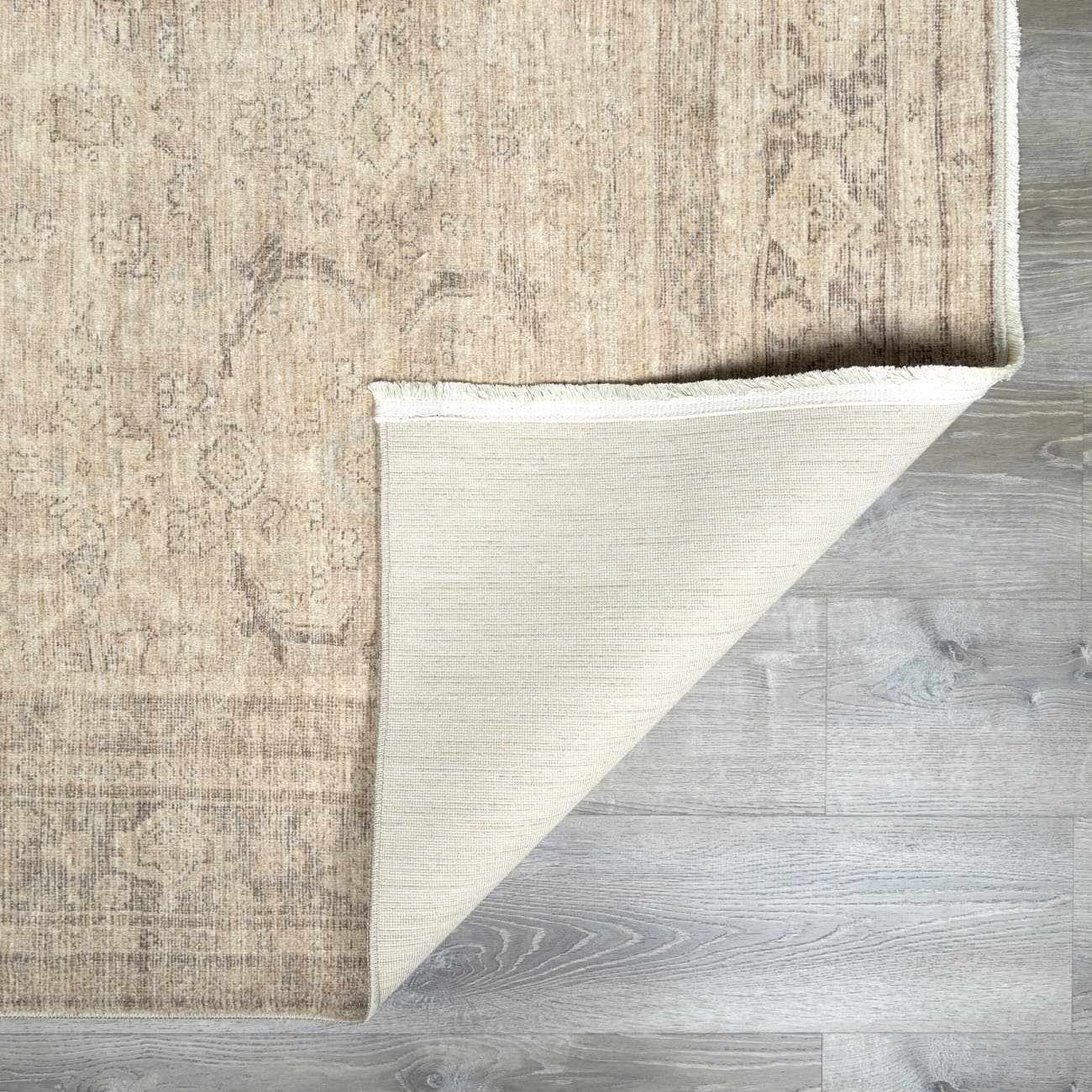 Close-up of the Fetscher V Vintage Damask Area Rug showing the tan damask pattern, ivory backing, and texture. Fold