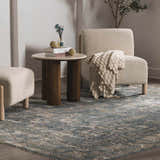 Living room scene with a Mirabel Denim Blue Traditional Rug, cream chair, and wood accent table. Roomscene-Rectangle