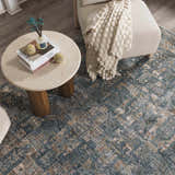 Living room scene with a Mirabel Denim Blue Traditional Rug, round coffee table, and cream armchair. Roomscene-Rectangle