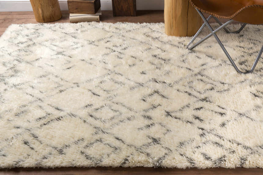 Close-up of a cream shag rug with a trellis pattern. The Cotgrave rug is made of wool and has a soft, textured feel. Styleshot