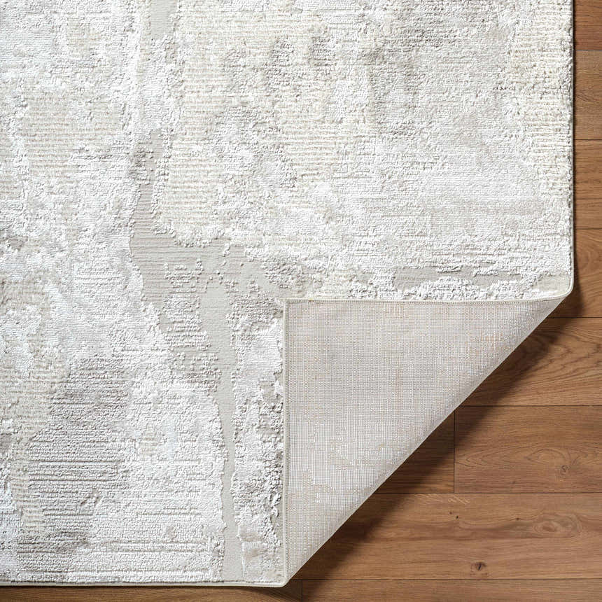 Close-up of the Chroma Abstract Cream Area Rug showing its abstract design, soft texture, and rug backing. Fold