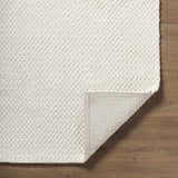 Close up of the Cqasce Navy Solid Hand Woven Wool Area Rug showing texture and backing. Fold