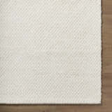 Close up of the hand woven texture of the Cqasce Navy Solid Wool Area Rug. Corner