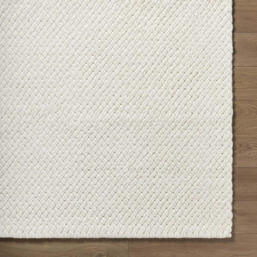 Close up of the hand woven texture of the Cqasce Navy Solid Wool Area Rug. Corner