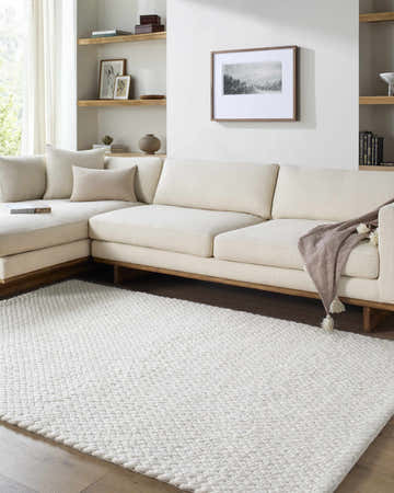 Living room scene with a cream sectional sofa and a Cqasce Navy Solid Hand Woven Wool Area Rug. Roomscene-Rectangle