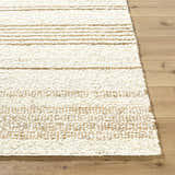 Close up of the hand woven Ciaran Area Rug, showcasing its ivory and sandstone stripes and wool texture. Front