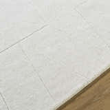 Close up of the ivory Callie Area Rug, showing the geometric pattern and hand loomed wool texture. Texture