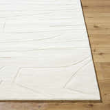 Close up of the off-white Camryn Area Rug showing its hand-loomed texture and contemporary geometric design. Front