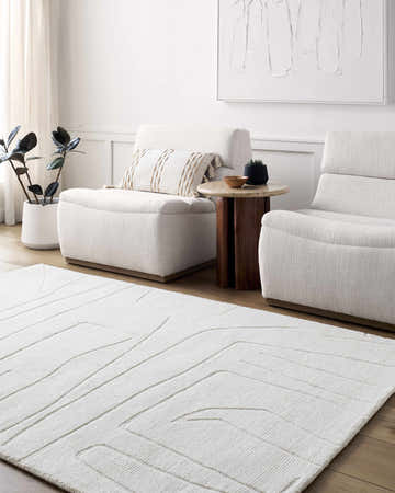 Living room scene with off-white Camryn Area Rug, two armchairs, side table, and minimalist art. Roomscene-Rectangle
