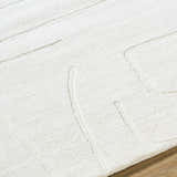 Close-up of the off-white Camryn Area Rug. Hand-loomed wool rug with a subtle geometric pattern and textured design. Texture