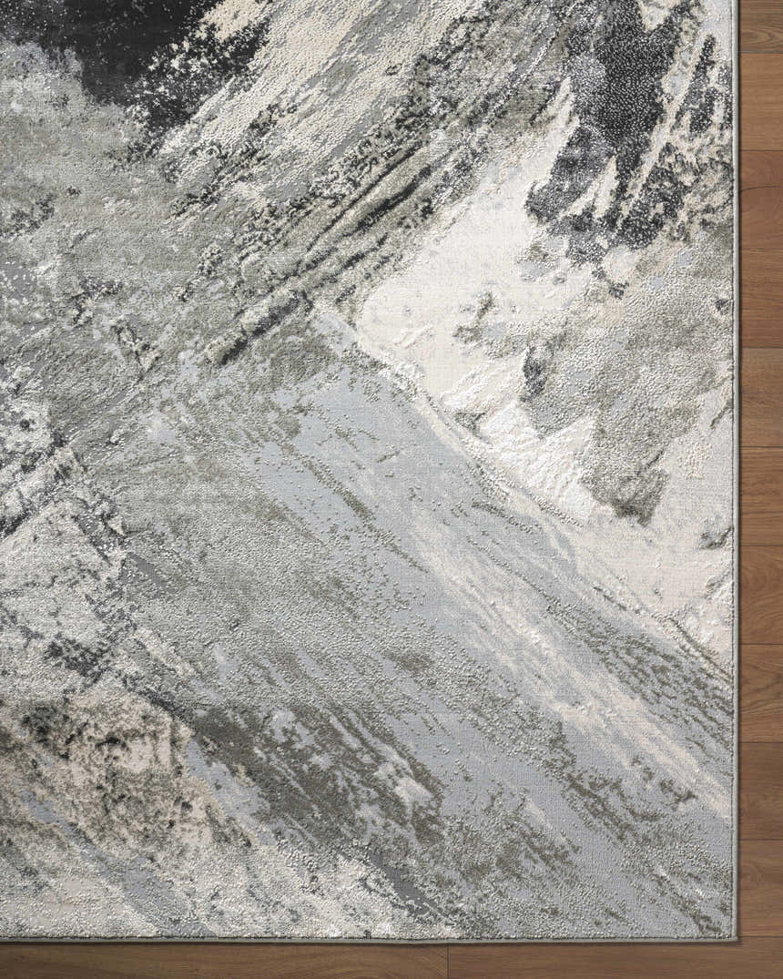 Close-up of the Chaeli Area Rug. Contemporary design with beige, black, charcoal, ivory, and light slate colors. Corner