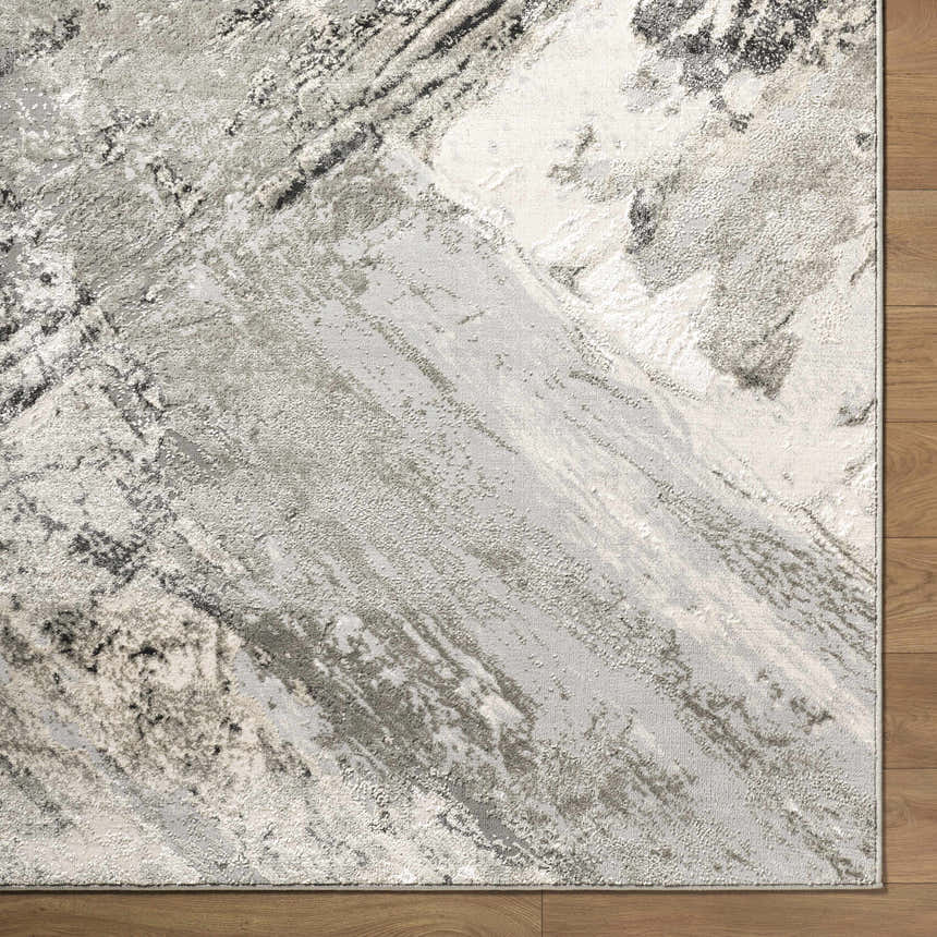 Close-up of the Chaeli Area Rug. Contemporary design with beige, black, charcoal, ivory, and light slate colors. Corner