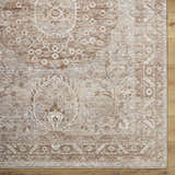 Close-up of Cosimo Area Rug. Farmhouse style rug in cream, dark red, gray, and tan with traditional floral pattern. Corner