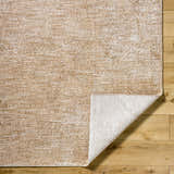 Close-up of the Cariel Beige Area Rug showing its textured, traditional pattern and tan, prairie dust colors on wood floor. Fold
