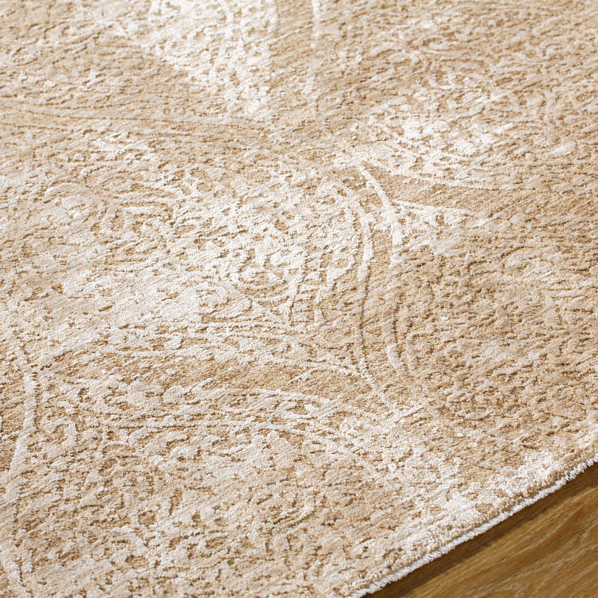 Close-up of the Cariel Beige Area Rug showing its traditional, textured pattern and soft tan and prairie dust colors. Texture