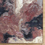 Close-up of the Chemed Area Rug. Abstract design in charcoal, crimson, ivory, mustard, and slate gray. Machine woven texture. Corner