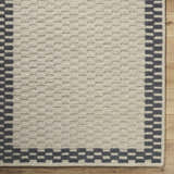 Close-up of the hand-tufted Camdyn Area Rug. Ivory rug with a charcoal checkerboard border, made of 100% wool. Swatch