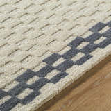 Close-up of the hand-tufted Camdyn Area Rug. Ivory wool rug with a charcoal geometric pattern. Contemporary style. Texture