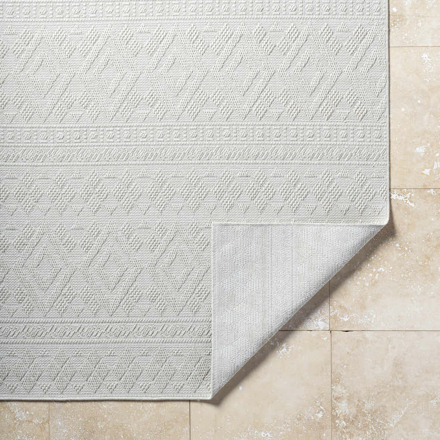Close-up of the light silver Choire Area Rug featuring a contemporary diamond pattern and machine woven texture. Fold