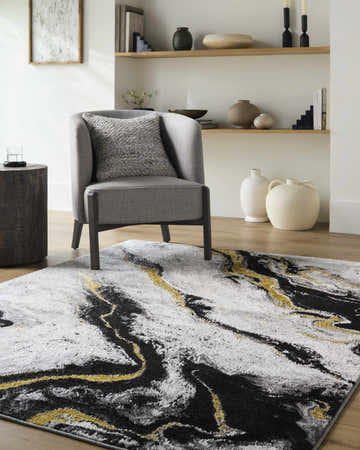 Living room scene with gray chair and Casmir Area Rug in black, charcoal, gray, ivory, and light slate. Roomscene-Rectangle