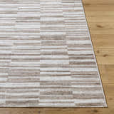 Close-up of the Cemach Light Brown Area Rug showing its contemporary stripe pattern and neutral light brown, silver, and white hues. Front
