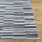 Close up of the Cemach Cream Area Rug showing a modern gray and white horizontal block pattern on wood flooring. Front