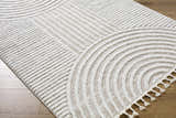 Close-up of the cream and peach Cassie Area Rug featuring a modern geometric design and tassels. Corner