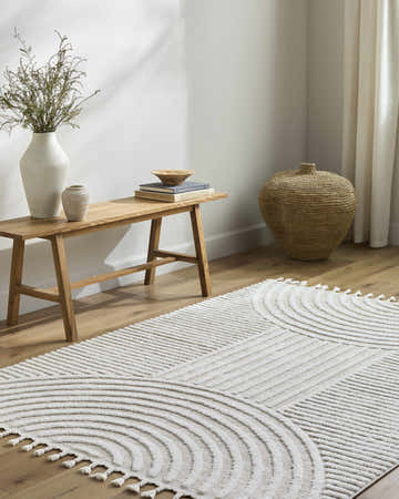 Minimalist living room scene with a cream Cassie Area Rug, wood bench, and neutral decor. Roomscene-Rectangle