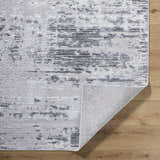 Close-up of the Candie Gray Area Rug showing its cream, ivory, and light gray contemporary pattern and texture. Fold