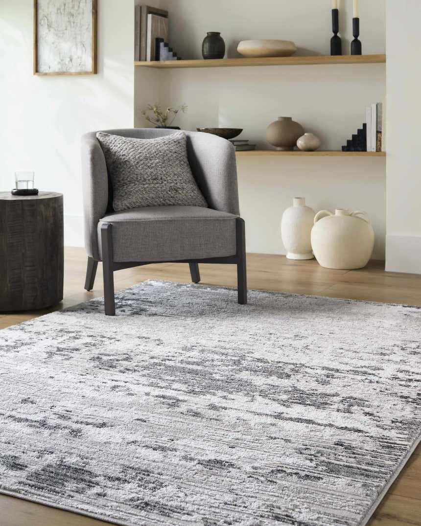 Living room scene with gray chair on Candie Gray Area Rug, wood floors and shelves with neutral decor. Roomscene-Rectangle