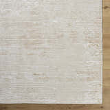 Close-up of the textured Candie Beige Area Rug with subtle cream and tan hues on a light wood floor. Corner