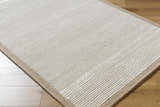 Close up of the hand-tufted Cianna Area Rug, a beige and ivory wool rug with a subtle striped pattern. Corner