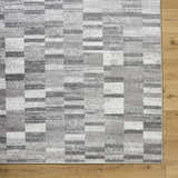 Close-up of the Cherie Medium Gray Area Rug showing its light silver, sage, and silver gray geometric pattern and texture. Corner