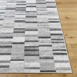 Close up of the Cherie Cream Area Rug showing its gray, light silver, and sage geometric pattern. Front