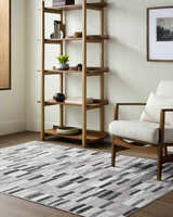 Living room scene with a Cherie Cream area rug, wood shelving unit, and mid-century modern chair. Roomscene-Rectangle